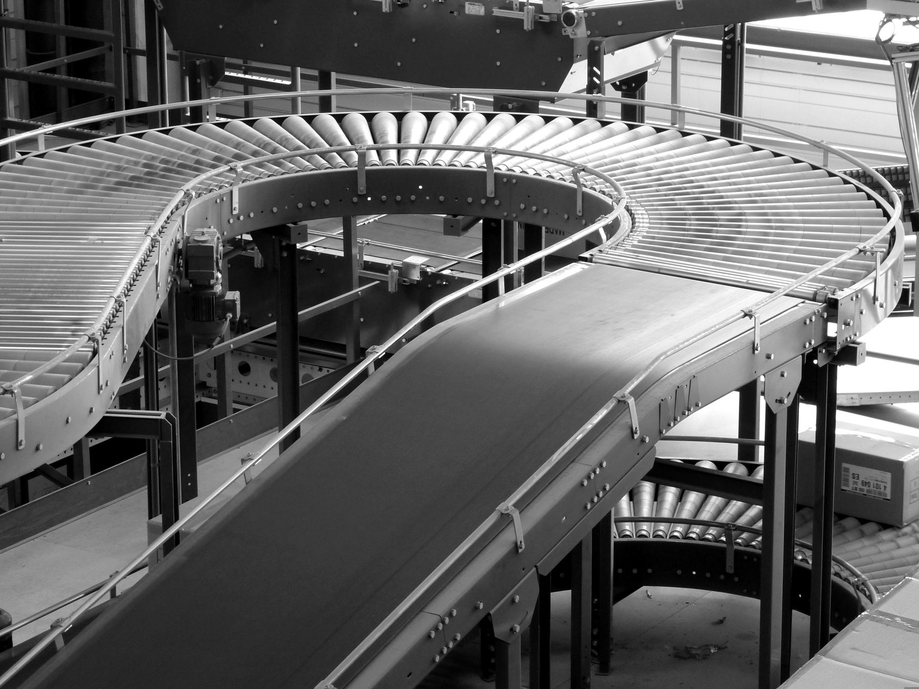 Conveyor belts curving through a plant, carrying things from one station to the next with no one lifting them