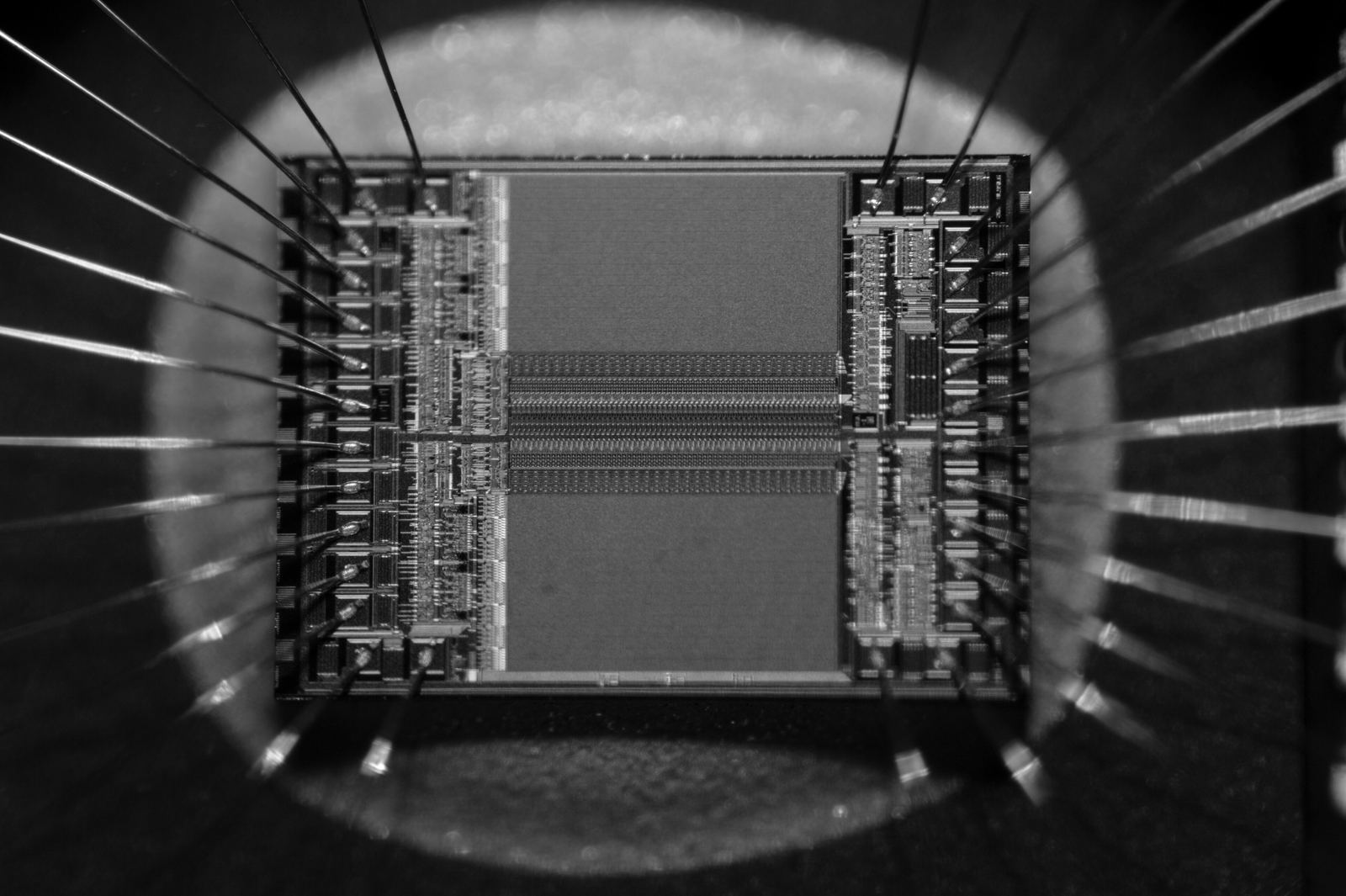 A microchip seen very close up, fine wires running from it to its pins