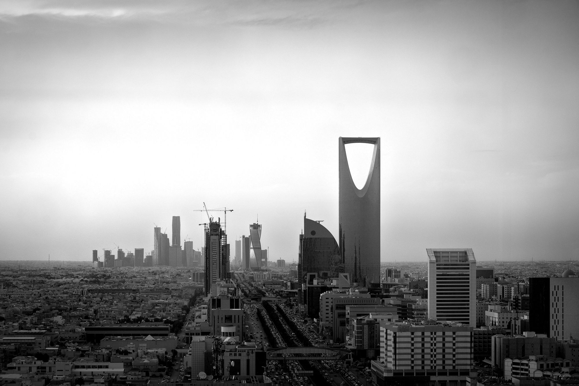 Kingdom Centre rising over Riyadh at sunset, the city spreading around it