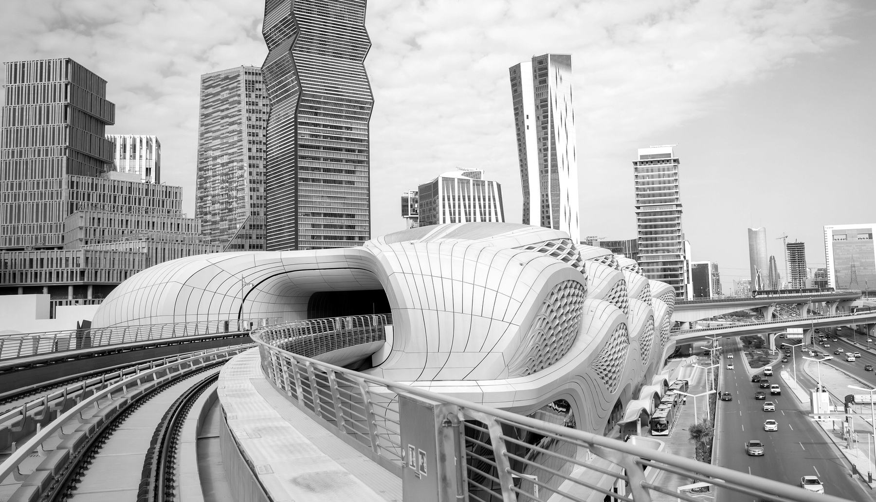 The Riyadh Metro station at the King Abdullah Financial District, its white rippled shell among the towers